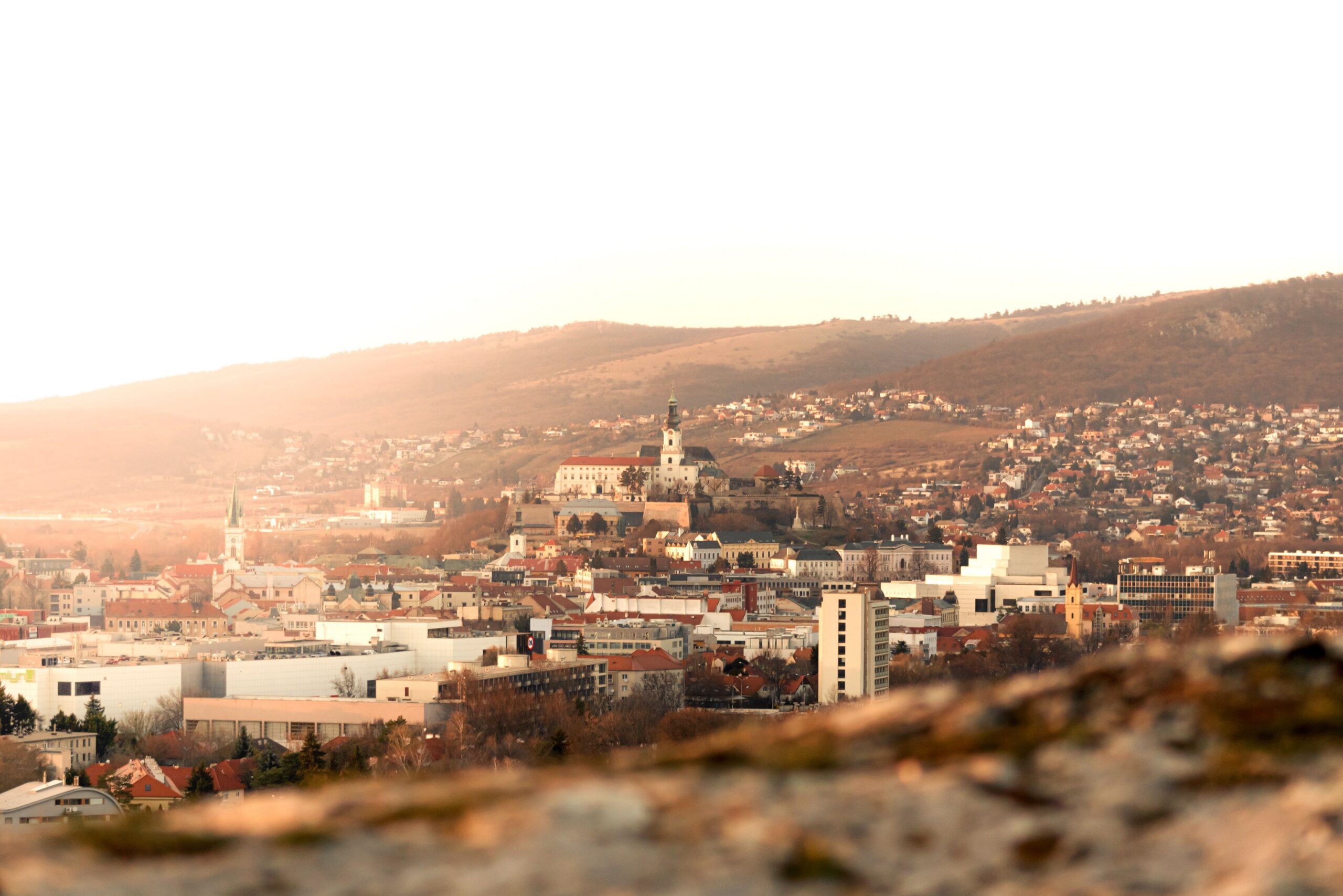 Stunning view of Nitra city and castle under a warm sunset glow.